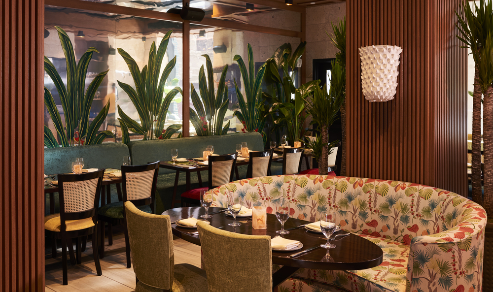 A dining area with a curved booth and tables set for meals.