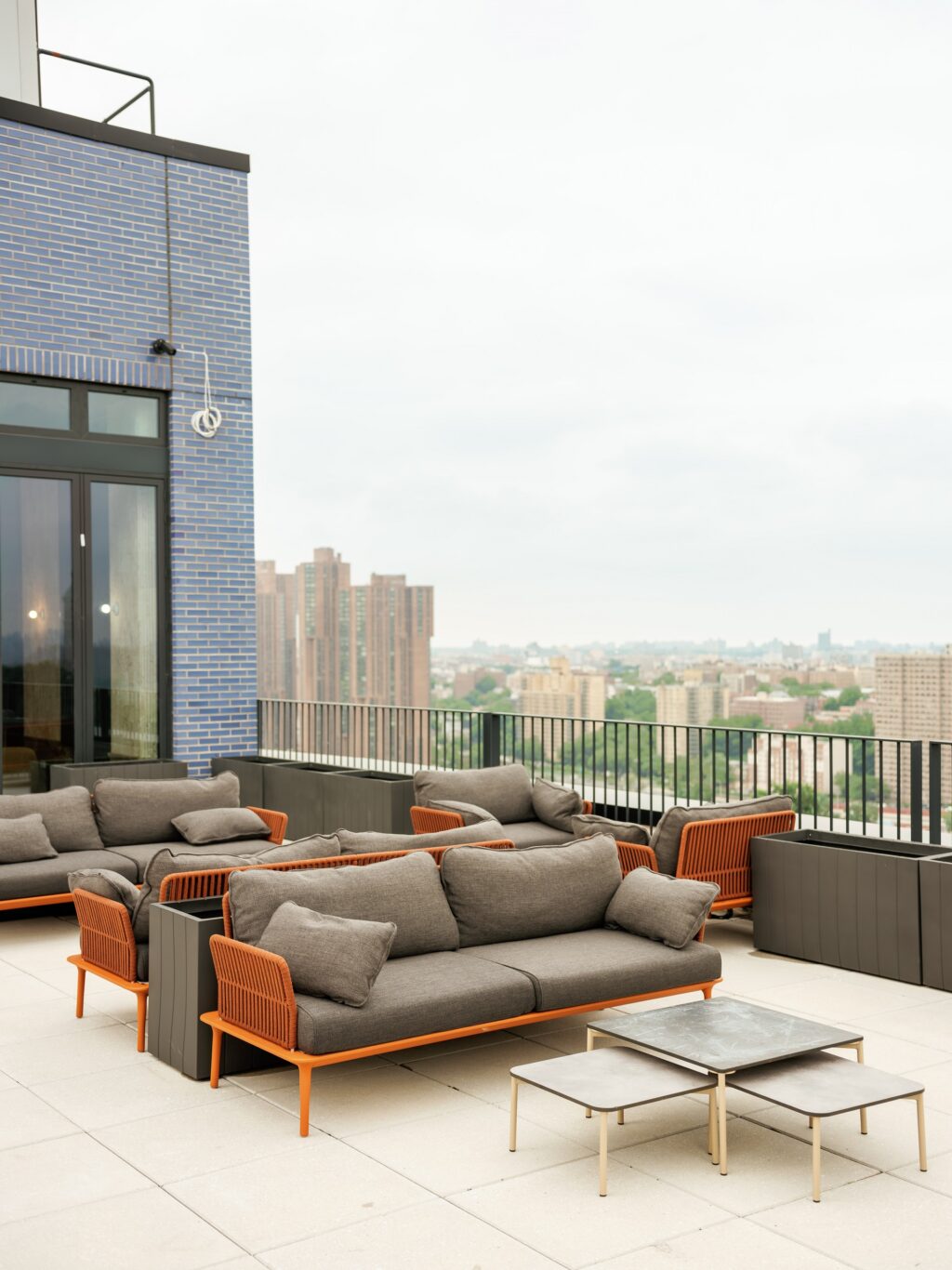 A rooftop lounge with outdoor furniture and a city view.