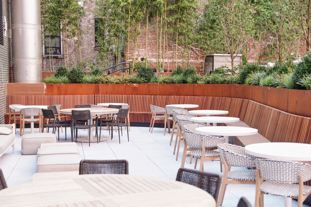 A patio area with outdoor seating and greenery