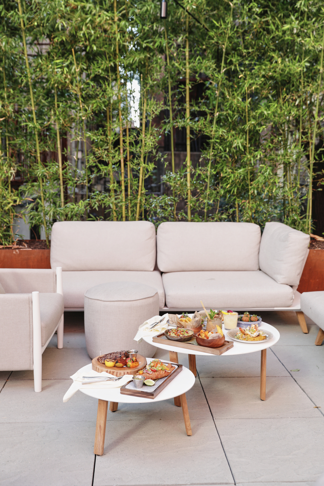 an outdoor dining area with white furniture and food on tables