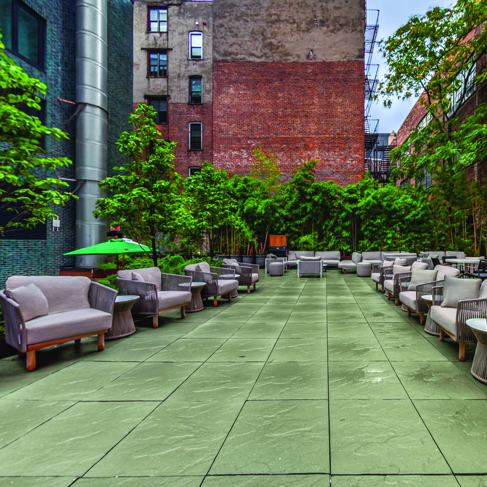 A green outdoor seating area with furniture and trees.