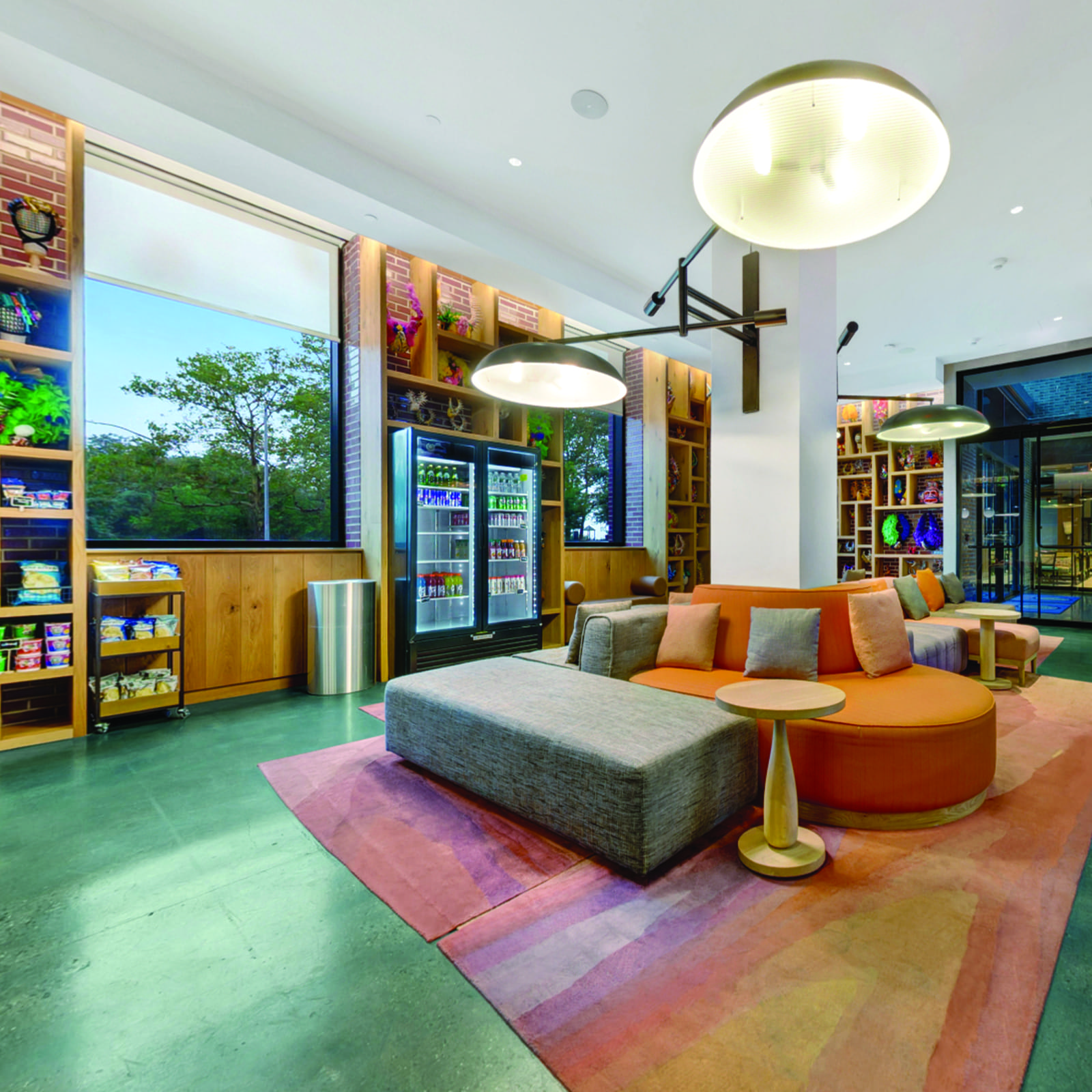 A hotel lobby with seating, a refrigerator, and shelving.