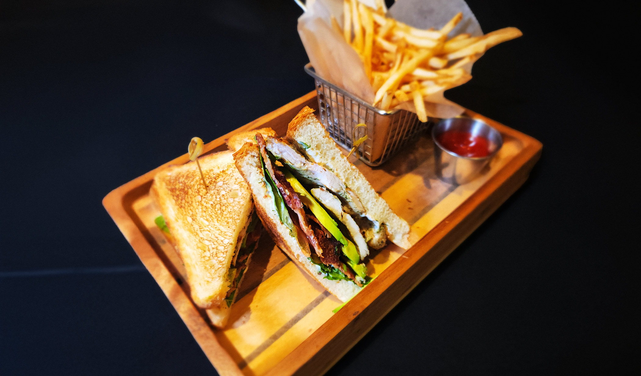 a sandwich and fries on a wooden tray